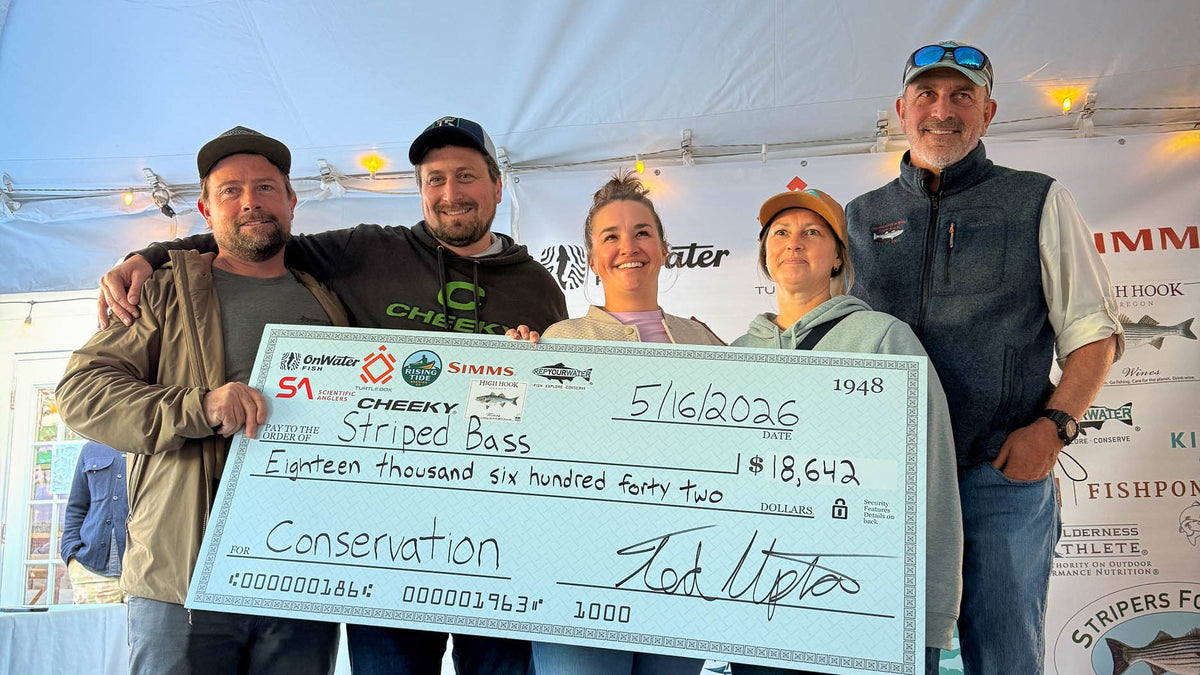 Group of people holding a large check under a tent